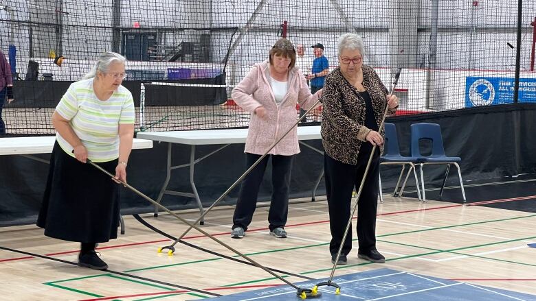 Three ladies playing shuffleboard