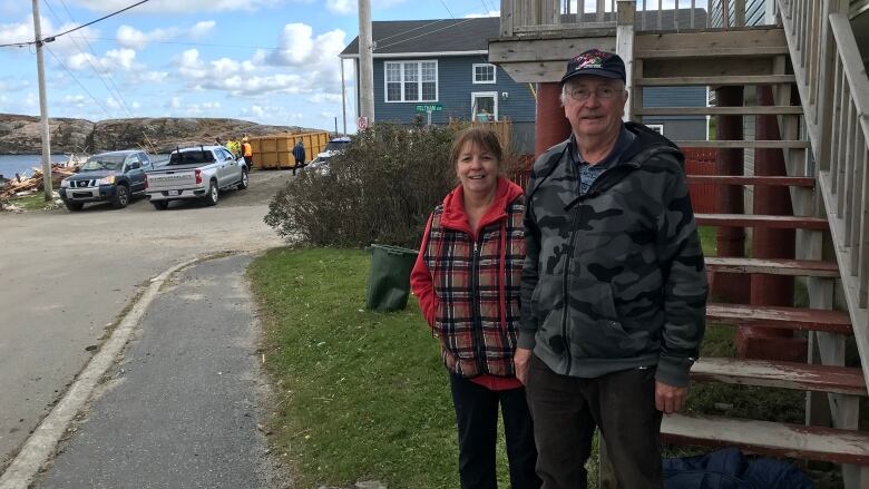 A couple stand in their yard in Port aux Basques.