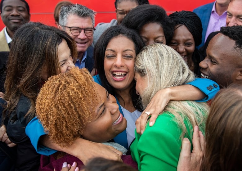 Local candidates hug their party leader after a news conference while on an election campaign. 