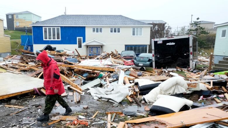 A Canadian Forces Ranger walks through the rubble of destroyed homes after post-tropical storm Fiona.