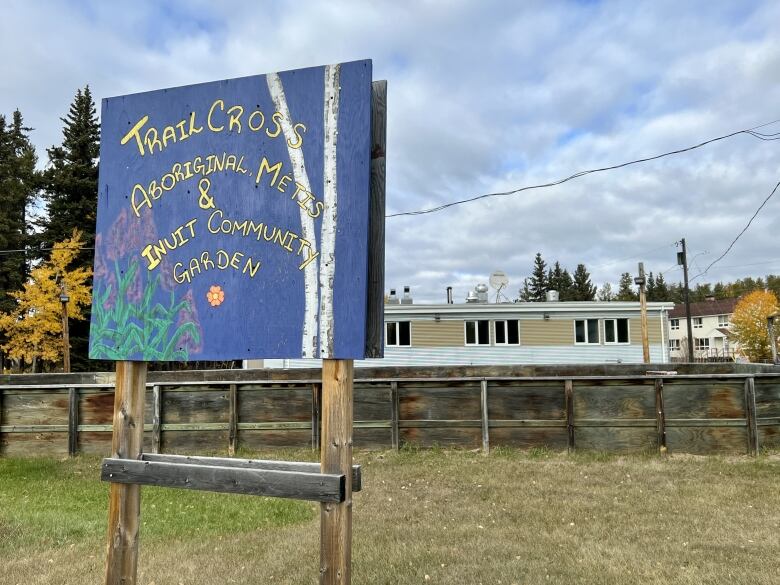 Handpainted sign in front of low building. 