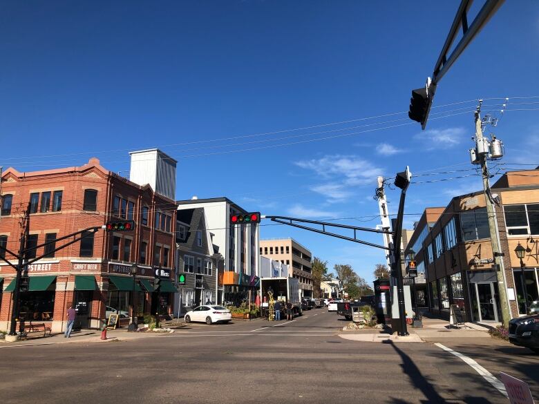 A view of a downtown street corner with restaurants and patios.