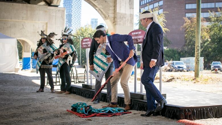 Members of Squamish Nation and Prime Minister Justin Trudeau break ground with shovels at the future Senakw housing development near the Burrard Bridge in Vancouver 