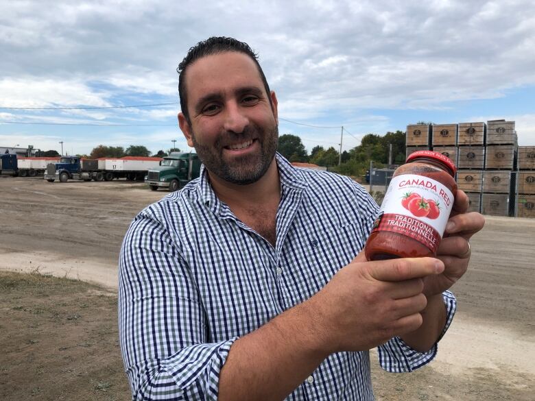 Highbury Canco CEO Sam Diab holds a jar of Canada Red pasta sauce they produce at their plant in Leamington.