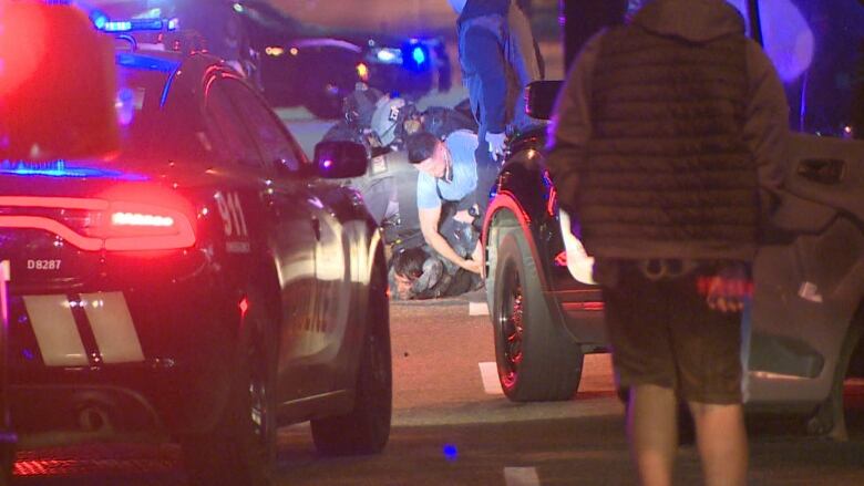 Vancouver police officers hold down a bank robbery suspect who allegedly barricaded himself inside a taxi for two hours on Thursday, Oct. 6, 2022.