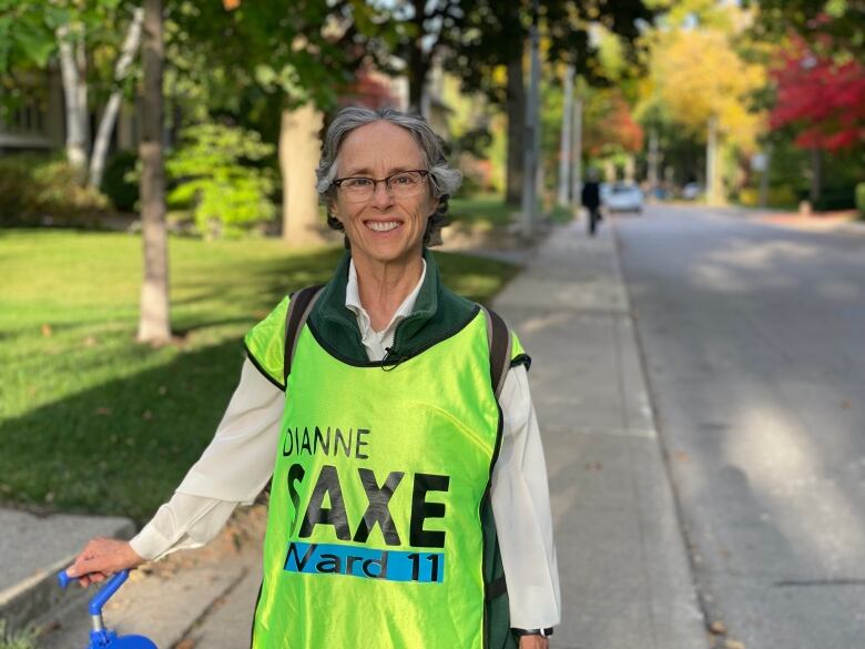 A smiling woman wearing a yellow pinny.