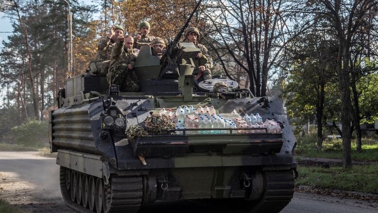 Ukrainian servicemen ride atop of an M113 armoured personnel carrier (APC) in the town of Lyman, recently liberated by the Ukrainian armed forces, amid Russia's attack on Ukraine, Donetsk region, Ukraine October 7, 2022.