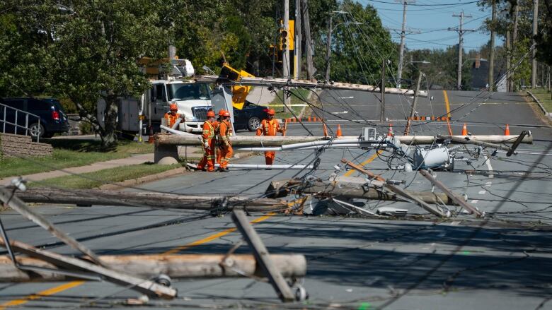 Workers assess downed power poles caused by post-tropical storm Fiona in Dartmouth, N.S., on Sunday, Sept. 25, 2022. 