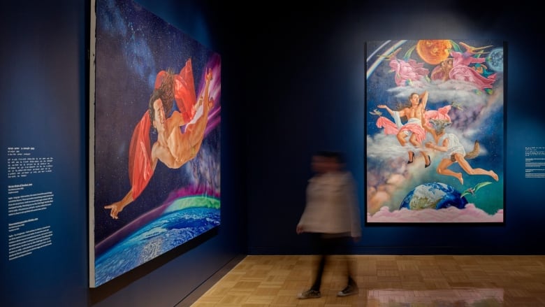 Installation view of Kent Monkman: Being Legendary at the Royal Ontario Museum. Two large acrylic paintings hang on dark blue walls.