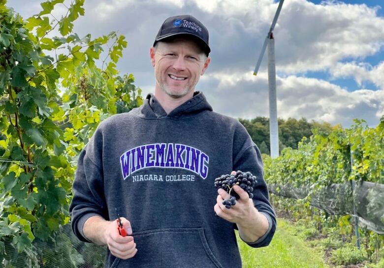 A man holds grapes used to make wine.