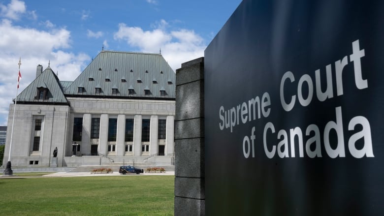 A sign reading Supreme Court of Canada stands in front of a courthouse.