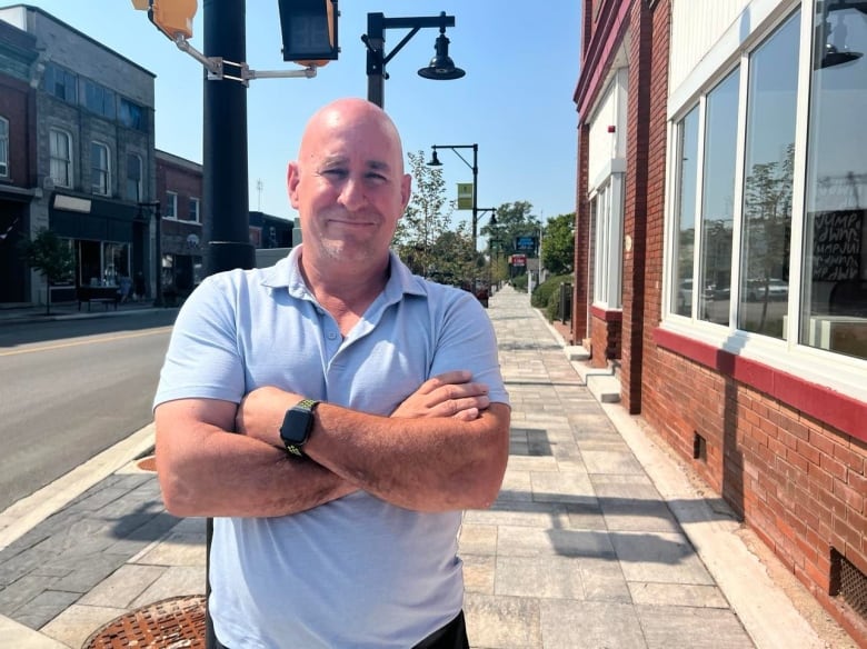 Rob Shepley on the sidewalk in a blue polo shirt.