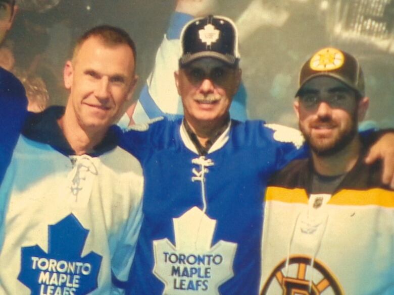 Three men in hockey jerseys.