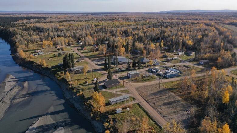 Aerial shot of small community on the side of a river in the fall. 