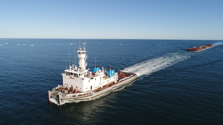 A barge sails through deep blue water.