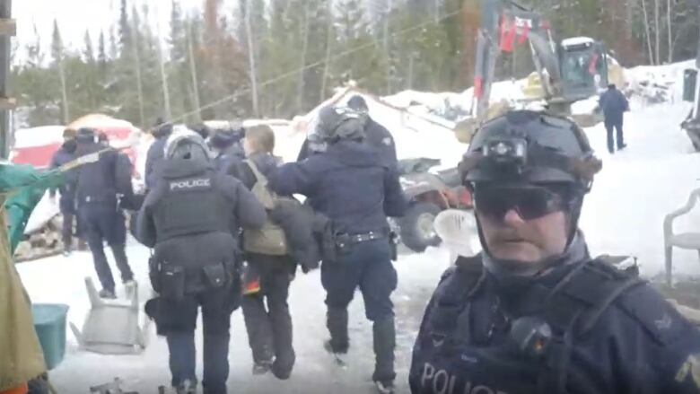 Uniformed RCMP officers arrest people. 