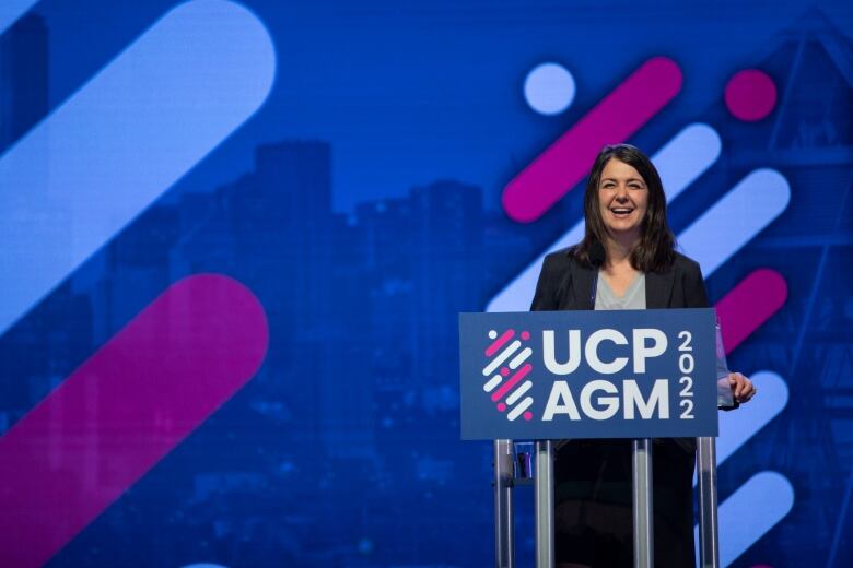 A woman stands in front of a podium. 