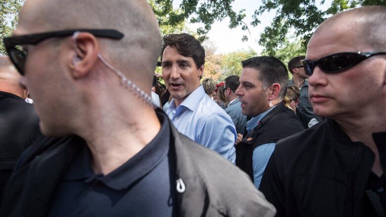 Prime Minister Justin Trudeau, back left, is surrounded by his security detail as he greets people in the crowd during a visit to B.C. Day celebrations in Penticton, B.C., on Monday August 6, 2018.