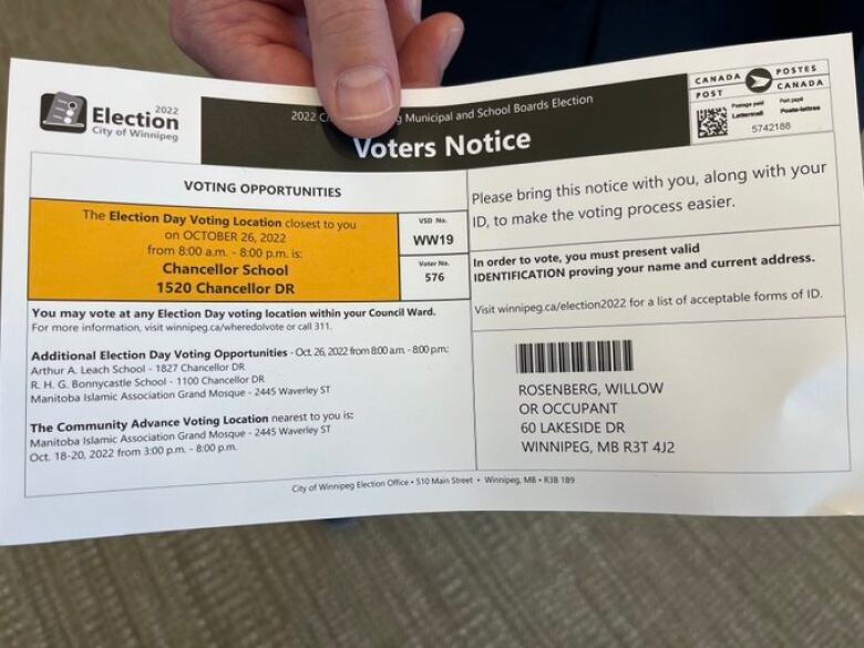 A person holds up a sample of a voter's notice made for Winnipeg's 2022 election.