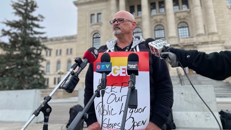 A man wearing a sign reading 