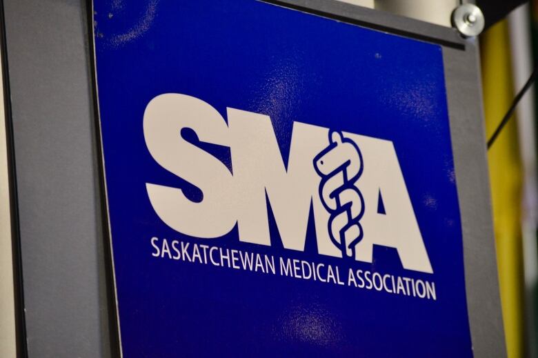 File - A sign featuring the logo of the The Saskatchewan medical Association (SMA) hangs on a podium. 