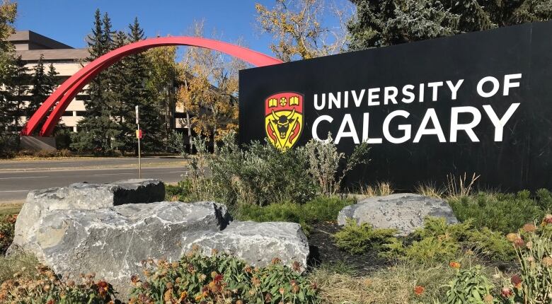 The University of Calgary sign is pictured at the campus entrance, on a sunny fall day. 