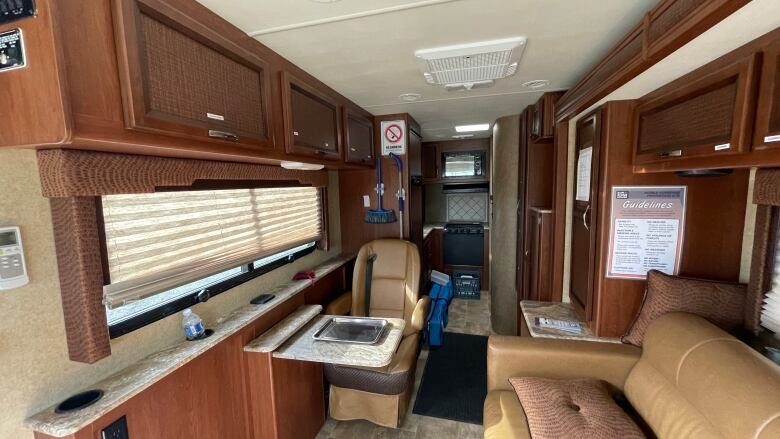 The interior of a converted RV, including a couch and a chair.