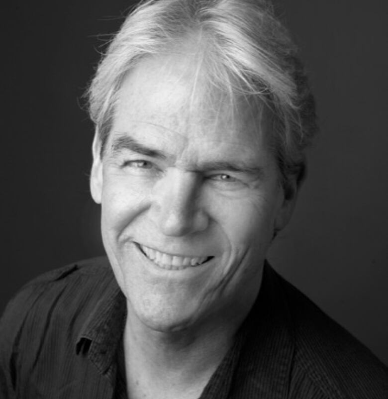 Black-and-white headshot of a man looking up toward a camera above him