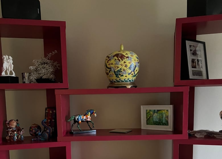 A set of shelves with small statues and other knicknacks.