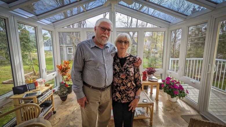 A couple stands in their sunroom 