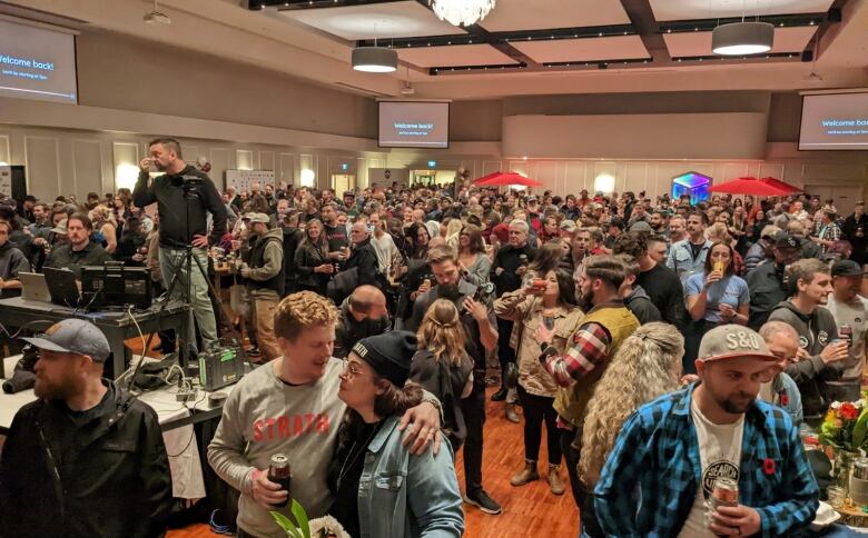 Hundreds of people in a crowded banquet hall.