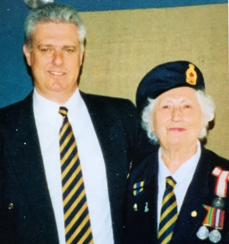 A husband and wife stand side-by-side in their Legion attire. 