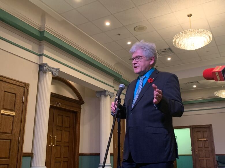 A man gestures to reporters