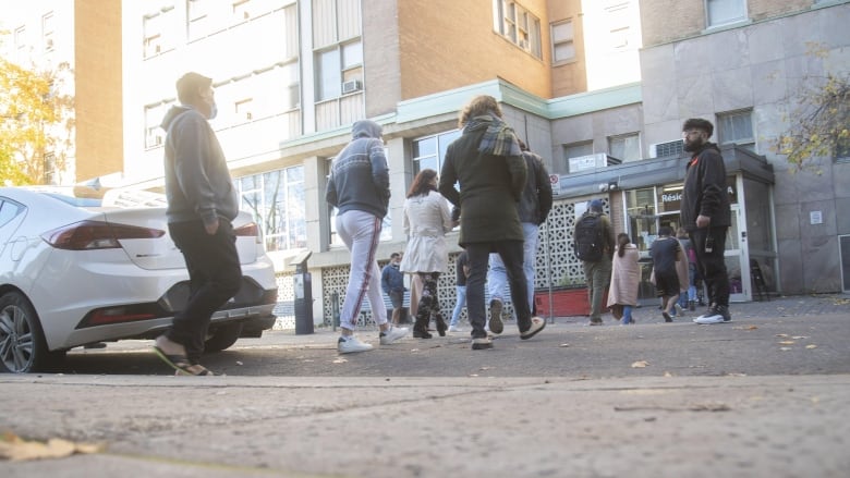 A group of people line up outside of a building. 