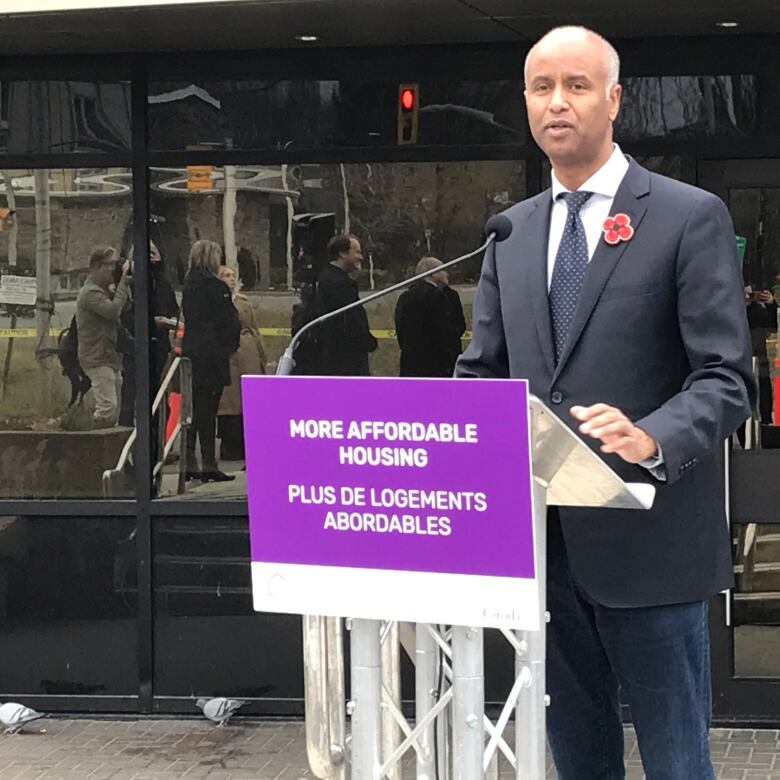 Minister Ahmed Hussen addresses a small crowd on a cold winter day in the parking lot at 200 Larch Street in downtown Sudbury.