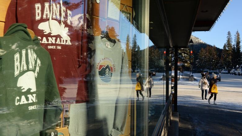 A store window reflects a snowy street. 