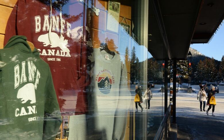 A store window reflects a snowy street. 