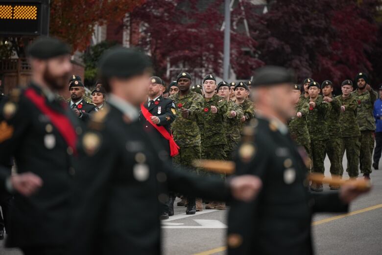 Members of the military march down a street.