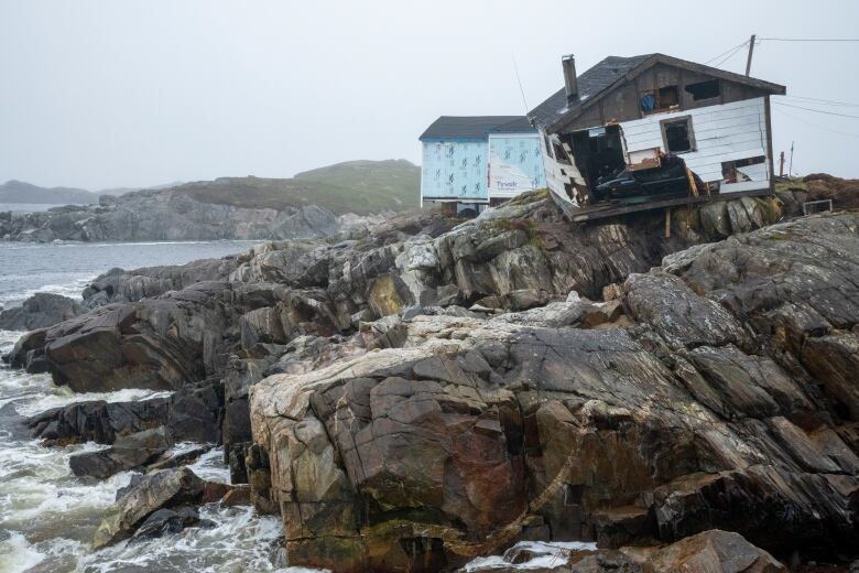 Destroyed houses perch on the edge of the rocks following hurricane Fiona in Burnt Island, Newfoundland and Labrador.