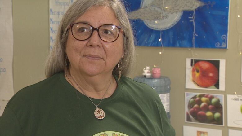 Woman with glasses with hair behind her back.