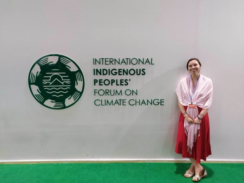 A woman smiles for the camera while attending a conference.