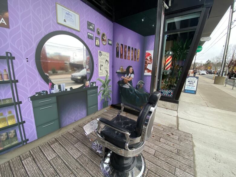 A barber's chair in front of an image of a mirror and hair styling desk