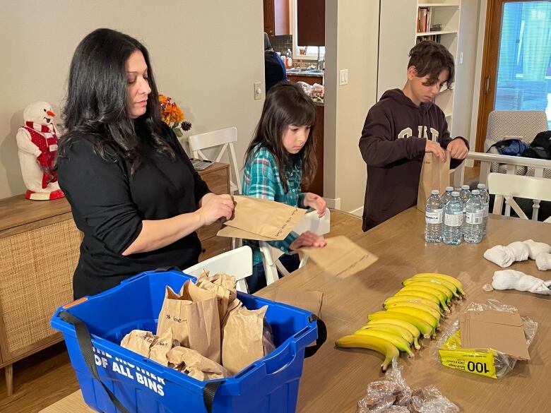 Three people assemble care packages.