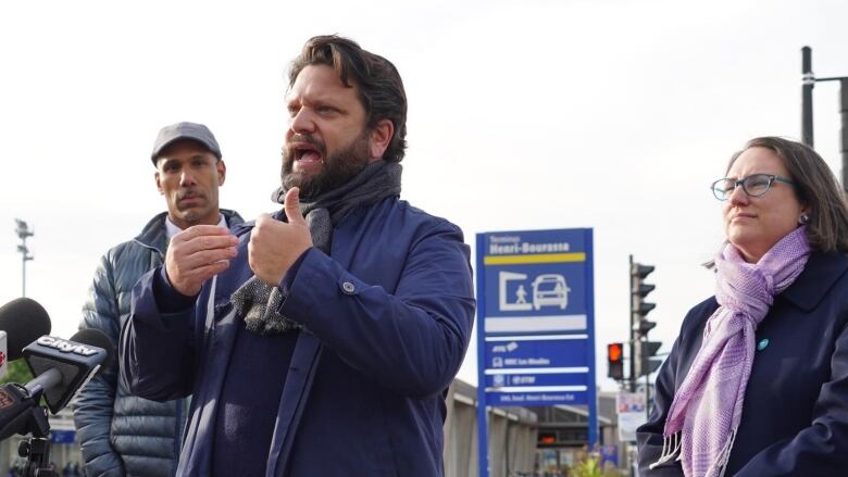 A man is speaking outdoors.