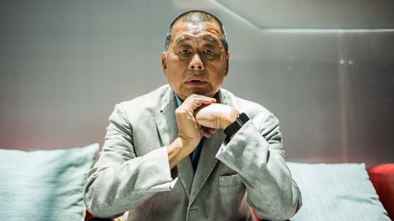 Close-up portrait of a man sitting on a red couch.