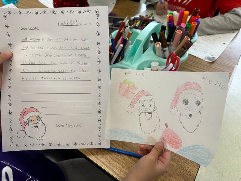 A hand-made letter in kid's writing that asks Santa for needs, which are clothes. 