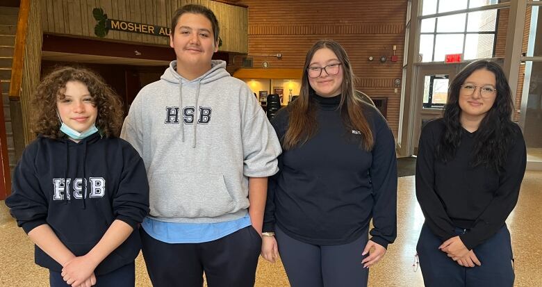 Four teens in an auditorium.