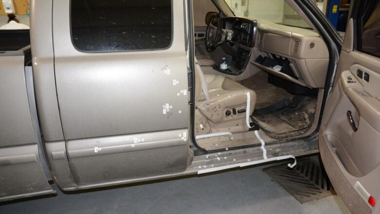 Stickers marking blood stains on a truck with an open passenger-side door.