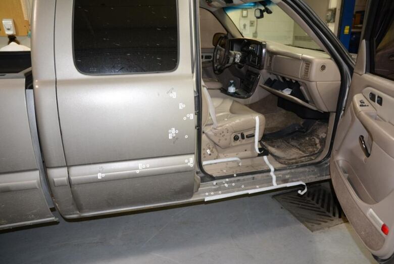 Stickers marking blood stains on a truck with an open passenger-side door.