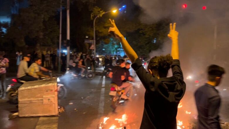 Picture obtained by AFP outside Iran shows shows a demonstrator raising his arms and makes the victory sign during a protest for Mahsa Amini, a woman who died after being arrested by the Islamic republic's 